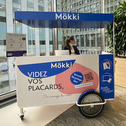 A mobile Mökki kiosk in a building with a Mökki representative